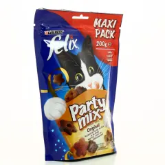 Un chat noir et blanc curieux regarde un paquet de friandises Felix Party Mix, parfait pour l'alimentation mixte chat.